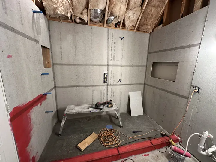 Shower build with a framed niche, cement board and waterproofed curb before tile