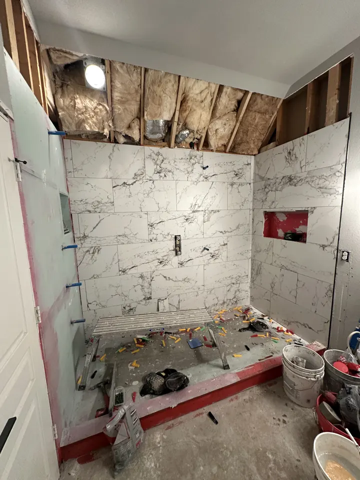 Large-format marble-look porcelain going up on the shower walls