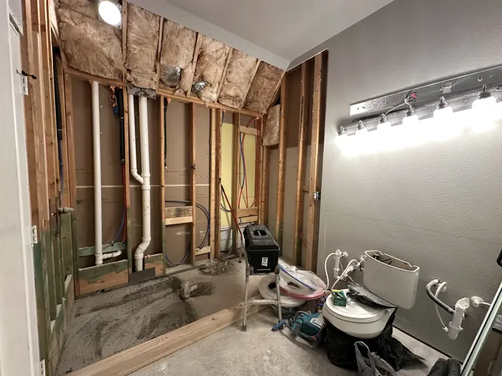 Shower wall opened to the framing with new supply lines being run