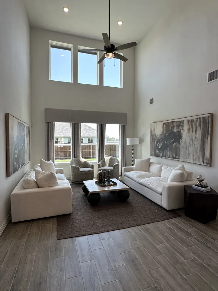 Two-story living room with wood-look plank flooring and fresh neutral paint
